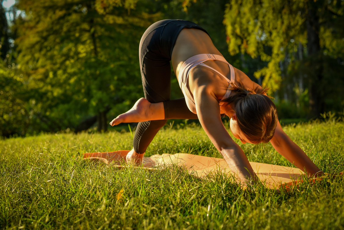 Attractive girl practicing yoga outside